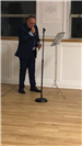 Black suit singing behind microphone stand