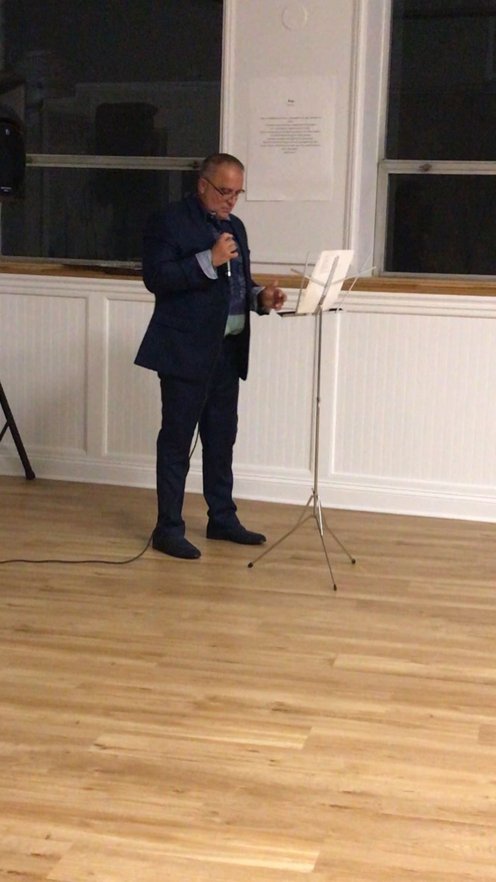 Man in black suit at composer stand