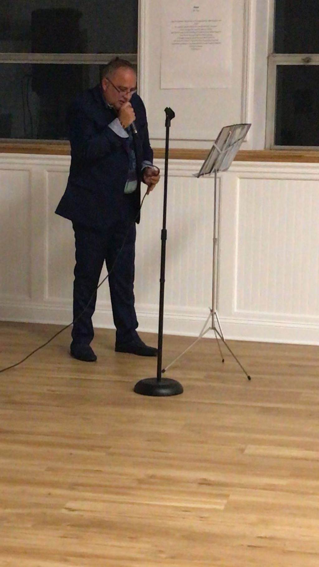 Black suit singing behind microphone stand
