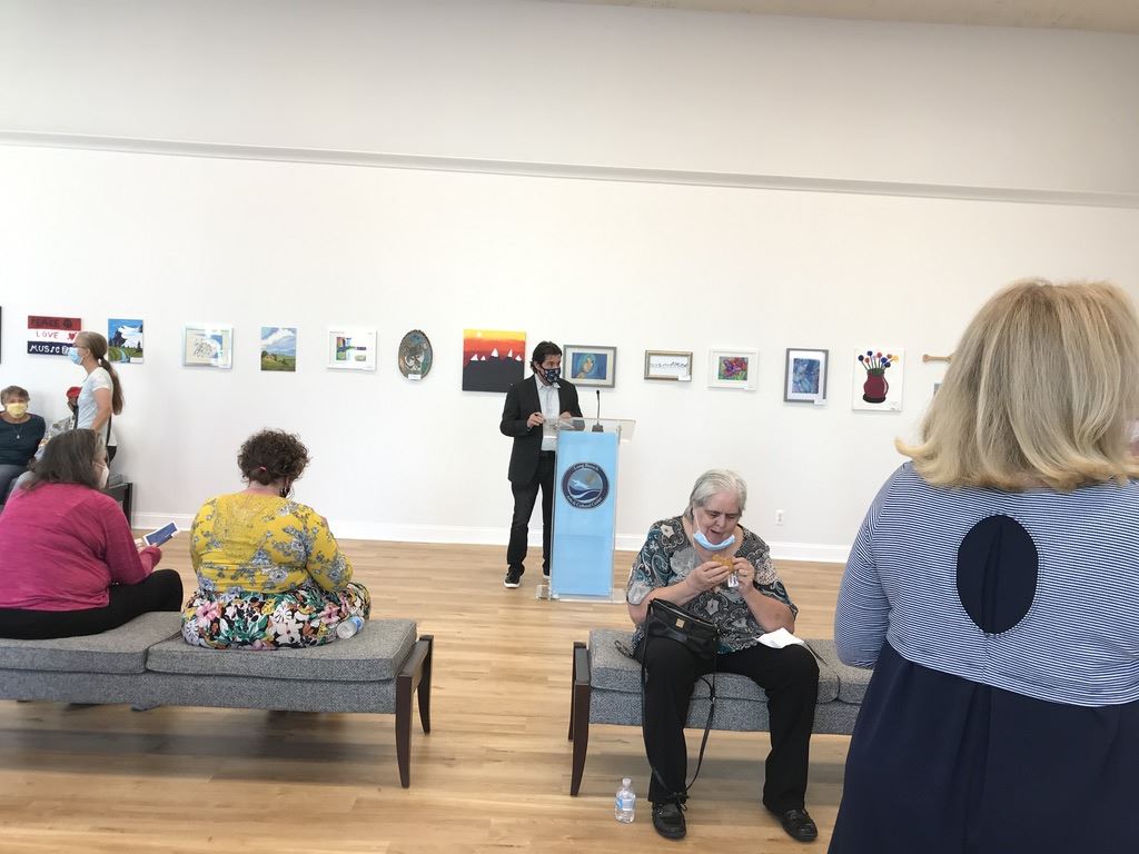 Speaker in front of gallery wall