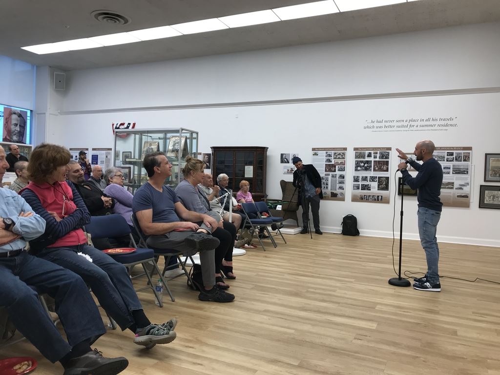Comedian with bald head in front of crowd