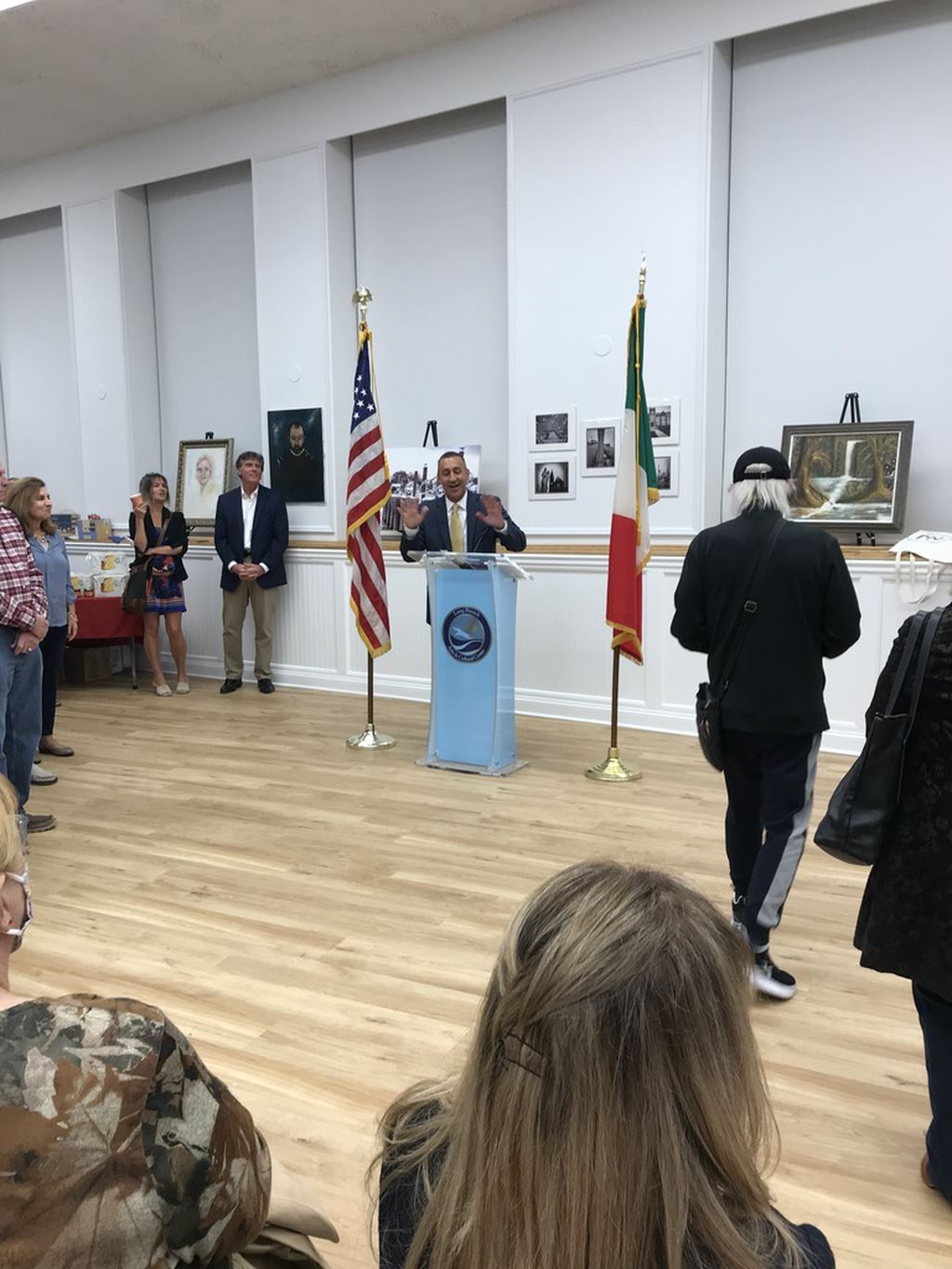 Man in suit at podium with hands in the air