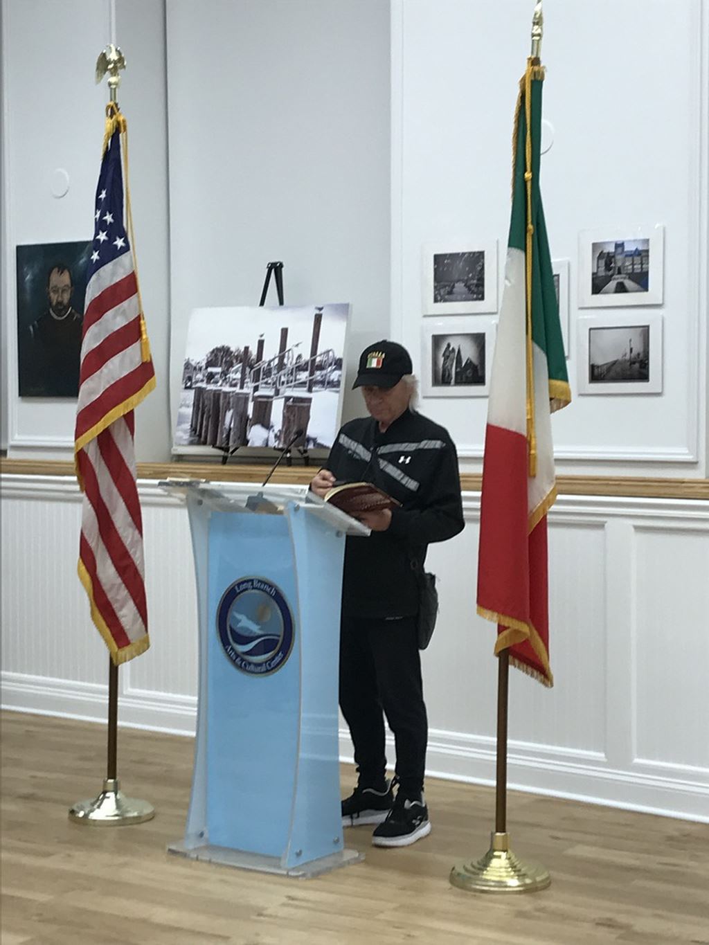 Man in black hat and coat at podium