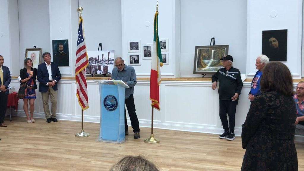 Man with glasses reading at podium