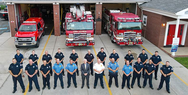 Looking down on Fire Department crew standing in front of Fire Station.